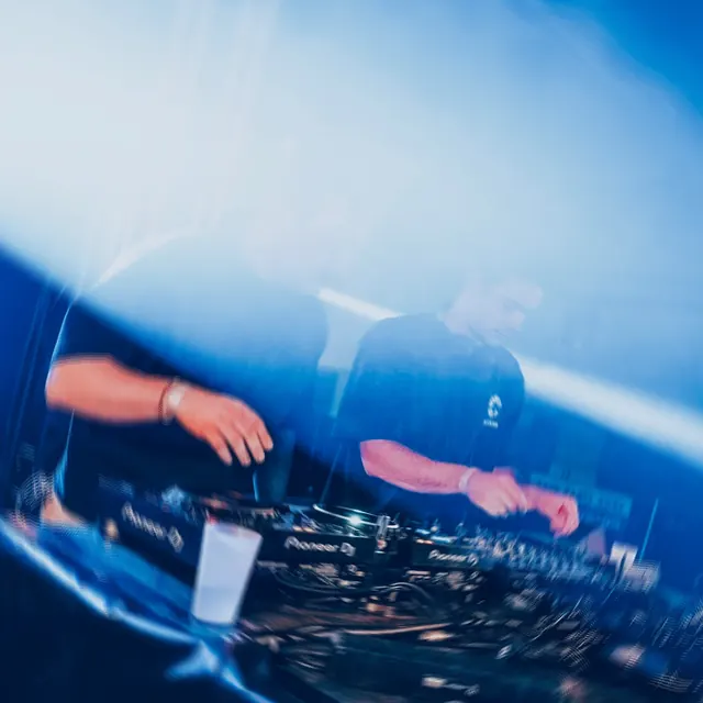 Close-up of hands on the mixer in blue light