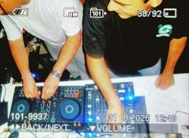 Camcorder shot from above of both DJs on the controller