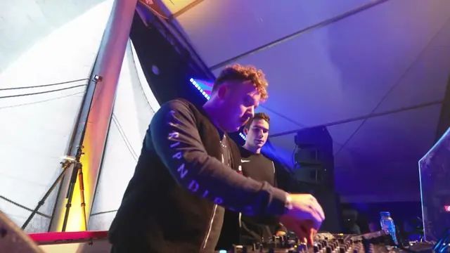 Both DJs in the booth under purple light at Schippersweekend